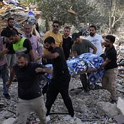 Personer bär ut en kropp från en byggnad som attackerats av Israel i södra Libanon på söndagen.