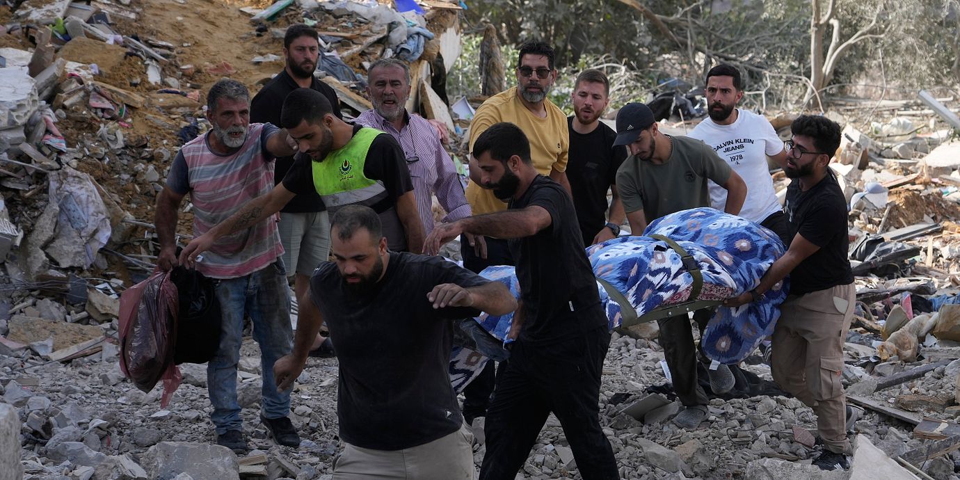 Personer bär ut en kropp från en byggnad som attackerats av Israel i södra Libanon på söndagen.