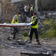 Räddningsarbetare bär på en person som dödats i en israelisk attack i södra libanon.