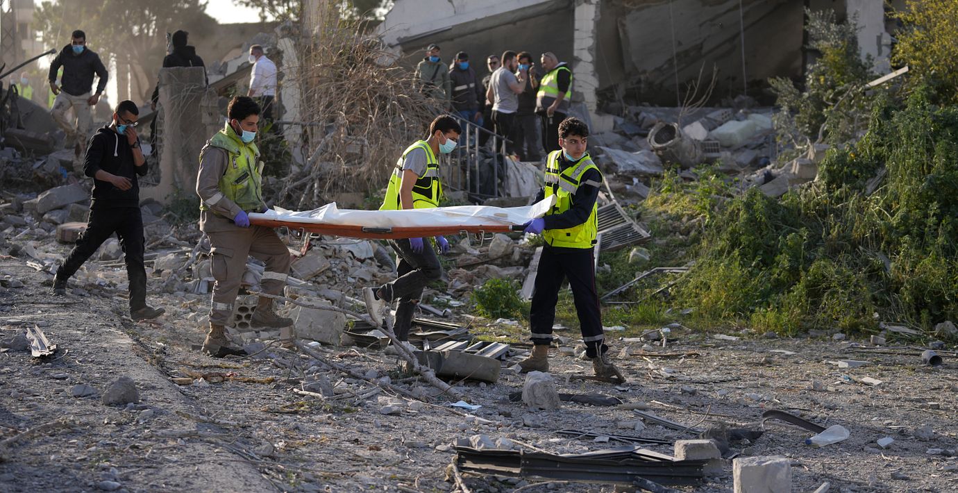 Räddningsarbetare bär på en person som dödats i en israelisk attack i södra libanon.