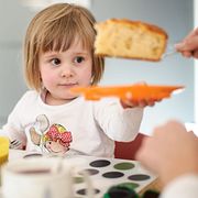 Barn äter en bit sockerkaka. Arkivbild.
