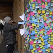 Det igenspikade hålet i Åhléns skyltfönster på Drottninggatan är täckt av postitlappar från förbipasserande måndagen efter terrorattacken.