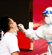 Sjukvårdspersonal utför ett coronatest.  Wang Guansen / TT NYHETSBYRÅN