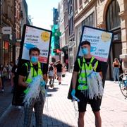 Personer i Amsterdam som påminner om att det masktvång i vissa delar av staden. 