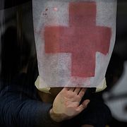 En person håller upp ett papper med ett rött kors mot vindrutan på en buss med civila som evakueras från Irpin 9 mars. 