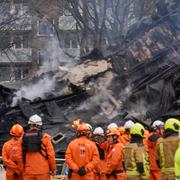 Brandmän vid huset där en enorm explosion inträffade i helgen.