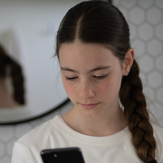 En flicka tittar på sin mobiltelefon/meddelandet till föräldrar.