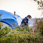 Avspärrningar kring ett tält och polis och kriminaltekniker på plats på Ön på Limhamn på lördagsmorgonen.