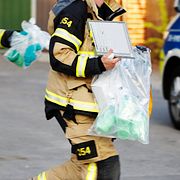 Räddningstjänstpersonal bär ut föremål i plastpåsar från en förskola i Gustavsberg där man hittat giftampuller