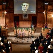 Edward Snowden, på skärm, applåderas vid utdelningen av Right Livelihood Award i riksdagens andrakammarsal.