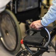 En äldre person tar sig runt med hjälp av en rollator på ett äldreboende .