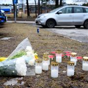 Blommor och ljus på parkeringen utanför skolan där 18-åringen sköts.