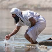 En anhängare av den sabéisk-mandeiska tron utför sina ritualer i Tigrisfloden i Bagdad i  mars 2024.