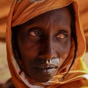 En person som flytt våldet visar upp sin nedbrända by på sin telefon.