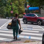 Hemlös kvinna bär sina ägodelar genom Washington DC, 13 augusti 2025. 