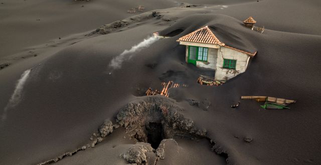 Ett hus i närheten av vulkanen täckt av aska. Emilio Morenatti / AP