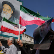 Folk håller iranska flaggor och bilder på ayatollah Ali Khamenei.