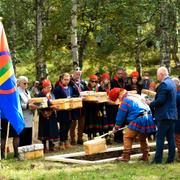 Forskaren Krister Stoor sänker ner en av de 25 näveraskar som innehåller kvarlevor under återbegravningen på försoningsceremonin vid Gammplatsen.