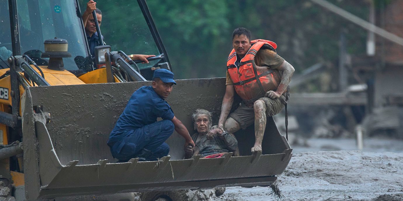 Räddningsarbetare för en person i säkerhet efter översvämningarna längs floden Trishuli i Nepal.