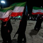 Kvinnor med den iranska flaggan visar sitt stöd för regimen.