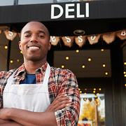 Black male business owner standing outside coffee shop