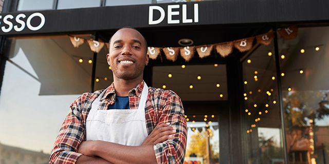 Black male business owner standing outside coffee shop Monkey Business Images