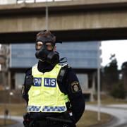 En polis i gasmask. Ett stort område spärrades av. 