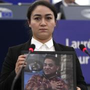 Jewher Ilham håller upp ett foto på sin fängslade far Ilham Tohti. 
