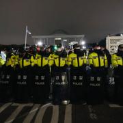 Poliser står på vakt framför parlamentet i Seoul. 