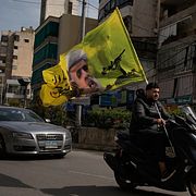 En man på en motorcykel håller i en flagga med Hizbollahs ledare Naim Qassem i Beirut. Arkivbild.