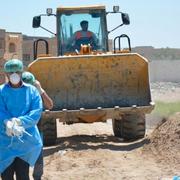 Irakiska säkerhetsstyrkor undersöker en massgrav i Ramadi