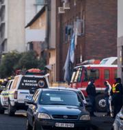 Räddningstjänstsfordon nära huset där storbranden bröt ut i Johannesburg i Sydafrika.  AP