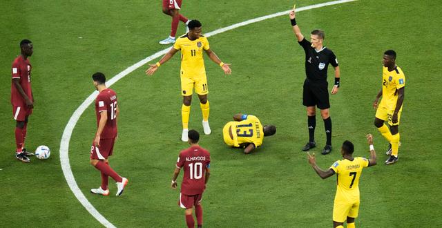 Referee Daniele Orsato, of Italy shows a yellow card to Qatar's Karim Boudiaf, second from left, during the World Cup group A soccer match between Qatar and Ecuador at the Al Bayt Stadium in Al Khor, Qatar, Sunday, Nov. 20, 2022. Hassan Ammar / AP