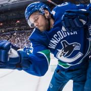 Alexander Edler delar ut en tackling på Torontos Zach Hyman under den första perioden.