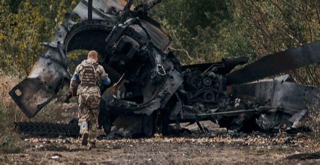 En ukrainsk soldat vid en förstörd rysk stridsvagn. AP