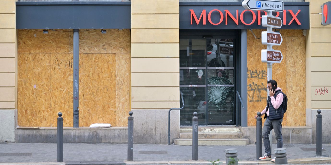 En man utanför en butik i Marseille som plundrats i helgen.