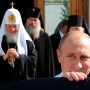 Vladimir Putin lämnar ett möte med patriark Kirill, till vänster i bild, 2014.