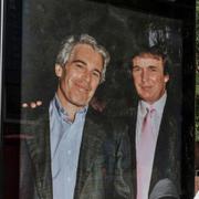 Aktivister sätter upp gamla bilder på president Donald Trump och Jeffrey Epstein nära amerikanska ambassaden  i London, 17 juli 2025. 