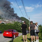 Personer står och kollar på branden i Drammen.
