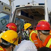 Räddningsarbetare för en av de räddade gruvarbetarna till en ambulans. 