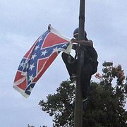 Arkivbild: En kvinna plockar ner en sydstatsflagga från ett minnesmärke i South Carolina, 2015.