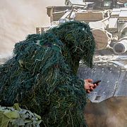 En rysk prickskytt kollar på sin telefon under en parad i Sankt Petersburg i Ryssland 2024. Prickskyttar på båda sidor har fått en allt mindre framträdande roll de senaste åren.