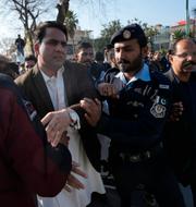 Polis stoppar demonstranter på väg mot svenska ambassaden i Islamabad. Anjum Naveed / AP