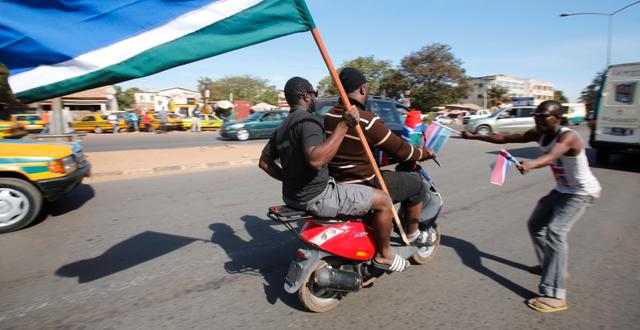Människor firar med Gambias flagga efter beskedet att Barrow ska återvända till landet THIERRY GOUEGNON / TT NYHETSBYRÅN