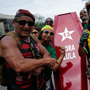 Anhängare till Flávio Bolsonaro med en kista med Lulas namn på och en Lulaanhängare utklädd till spindelmannen.