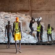 Arbetare lastar mat vid en nödhjälpsstation i Sudan. 