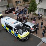 En polisbil för bort flera kvinnor från ett bostadsområde i Barking, östra London. 