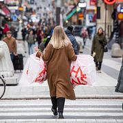 Kvinna bär kassar på shoppingstråket på Drottninggatan i Stockholm. Illustrationsbild.