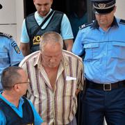 Gheorghe Dinca förs bort från domstolen i Craiova i södra Rumänen.