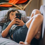 Ett barn använder sin mobil, illustrationsbild.